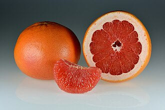 Whole and halved red grapefruit with peeled segments