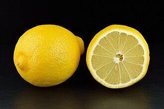 A whole lemon beside a cut half